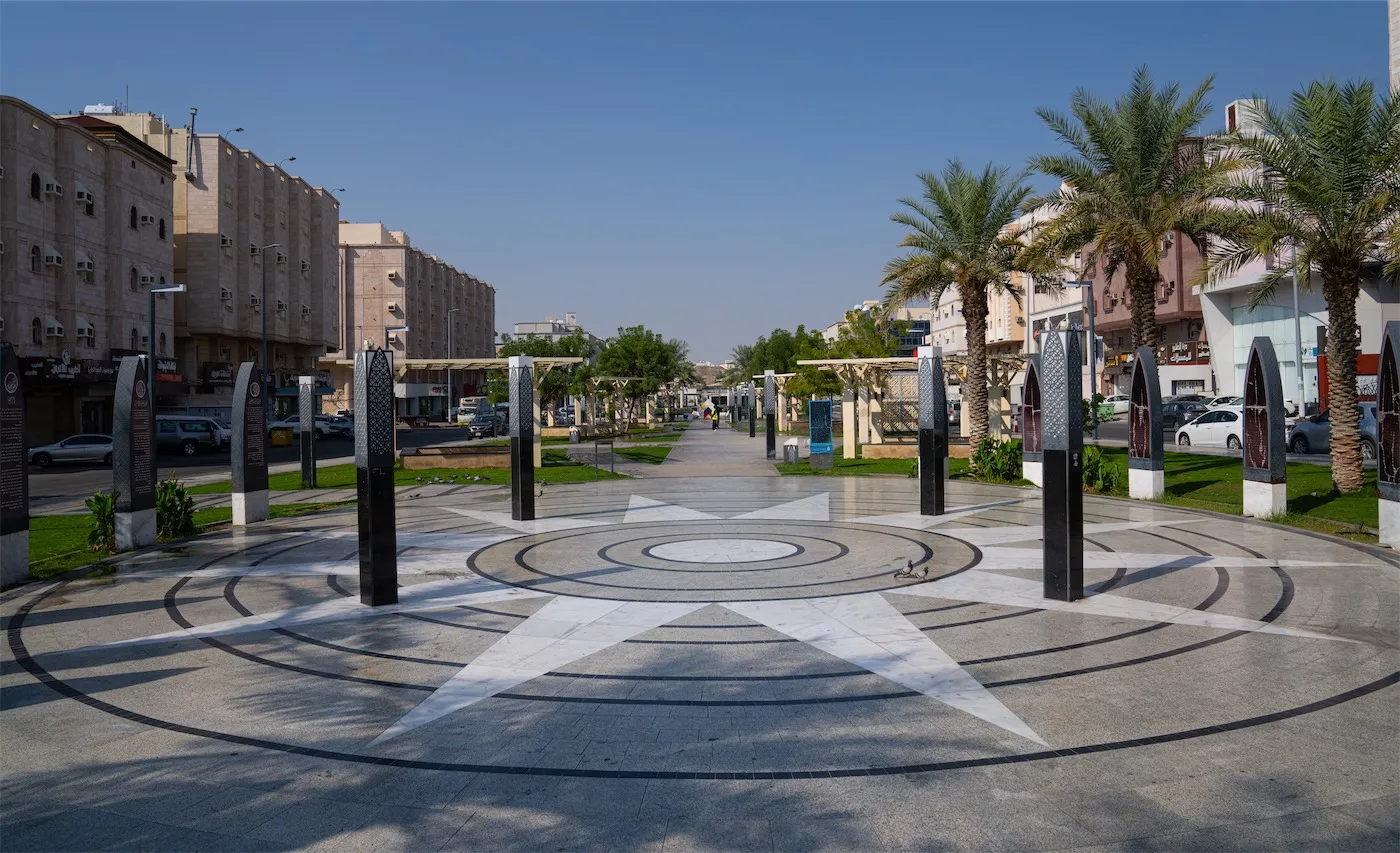 A wide pedestrian circular plaza with a star design at the entrance of Umm al-Mu'minin Zainab al-Hilaliyah Park and Walkway in Makkah.