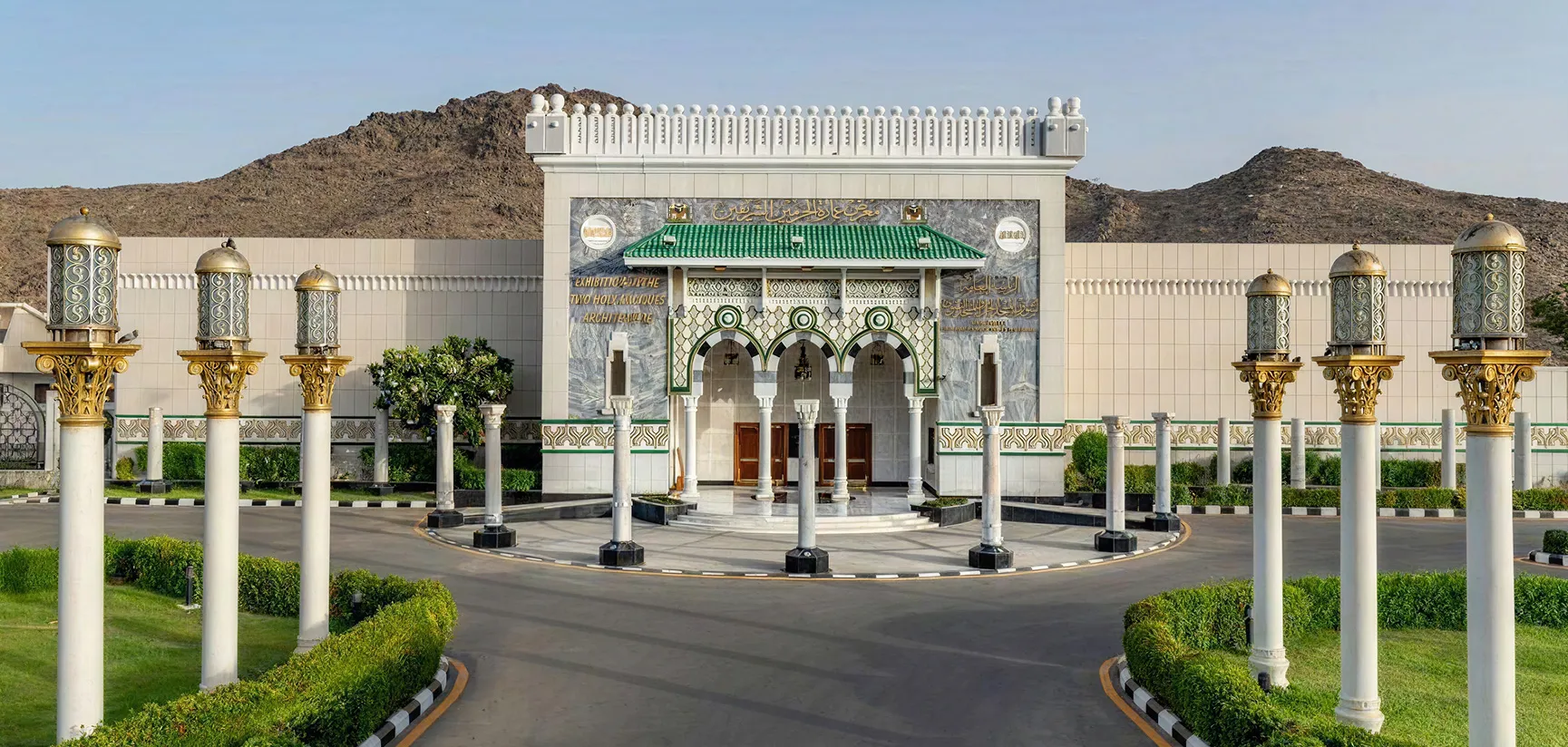 The main entrance of the Exhibition of the Two Holy Mosques Architecture in Makkah, featuring Islamic architectural designs and ornamental lamps.