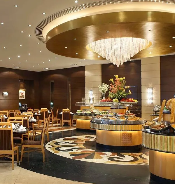 A spacious and sophisticated dining hall at Albayt Restaurant, showcasing the buffet layout and dining tables.