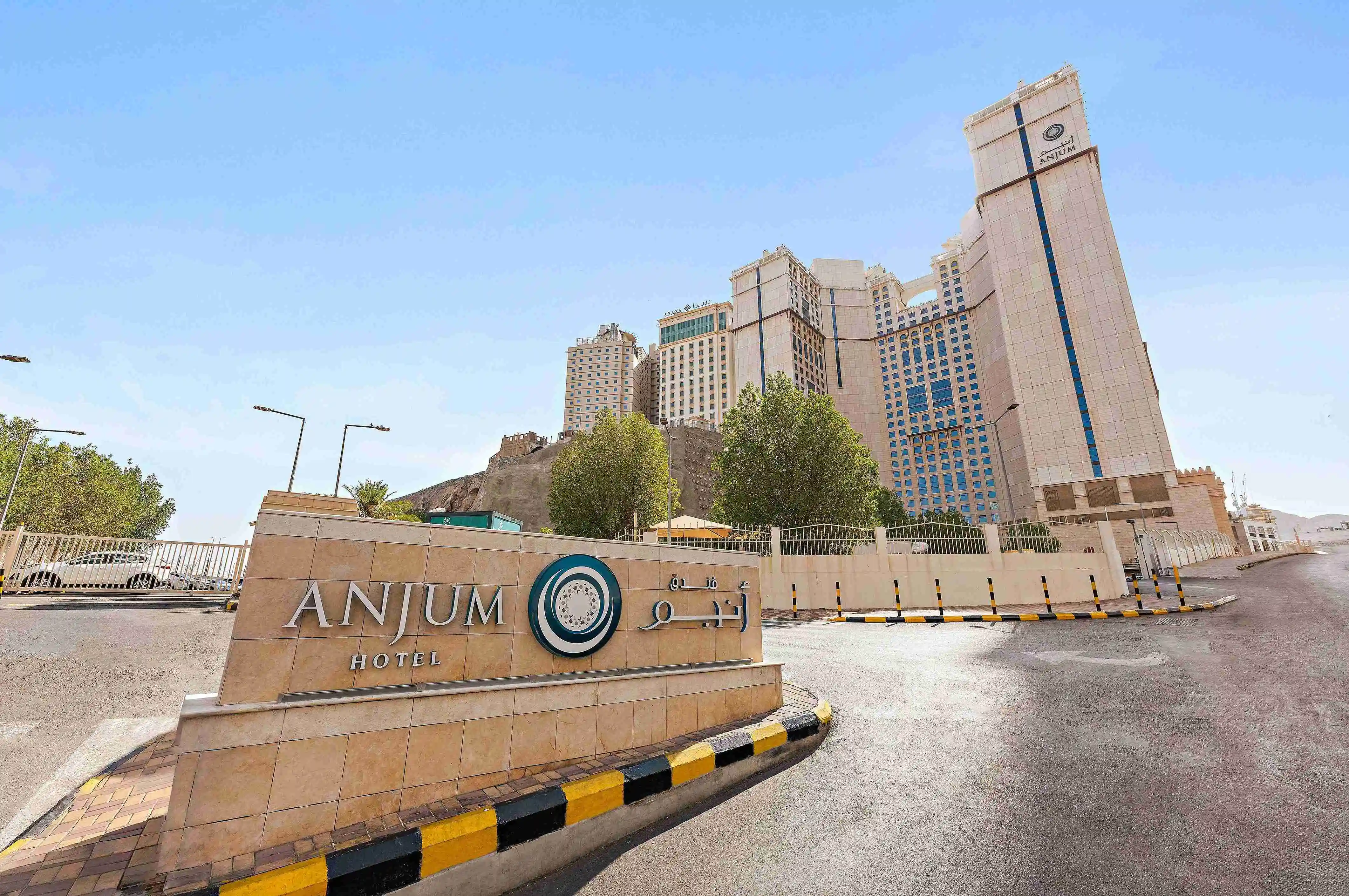 Exterior view of the Anjum Hotel Makkah building and its branded signage at the entrance.