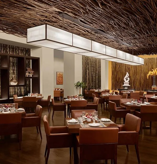A neatly organized buffet station at Sahteen Restaurant featuring various warm main dishes.