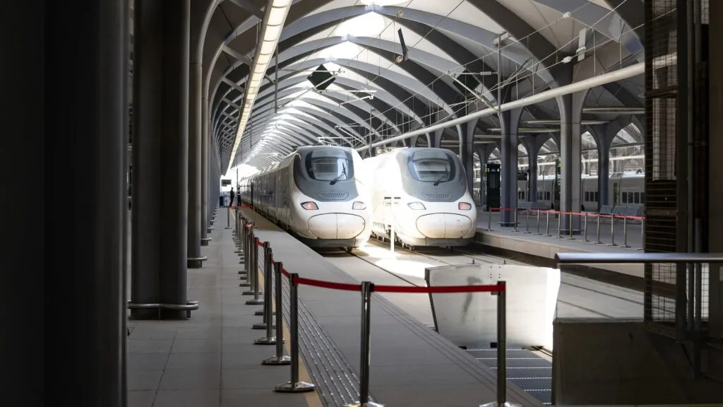 The Haramain High-Speed Railway train parked at the station platform under a modern architectural roof.