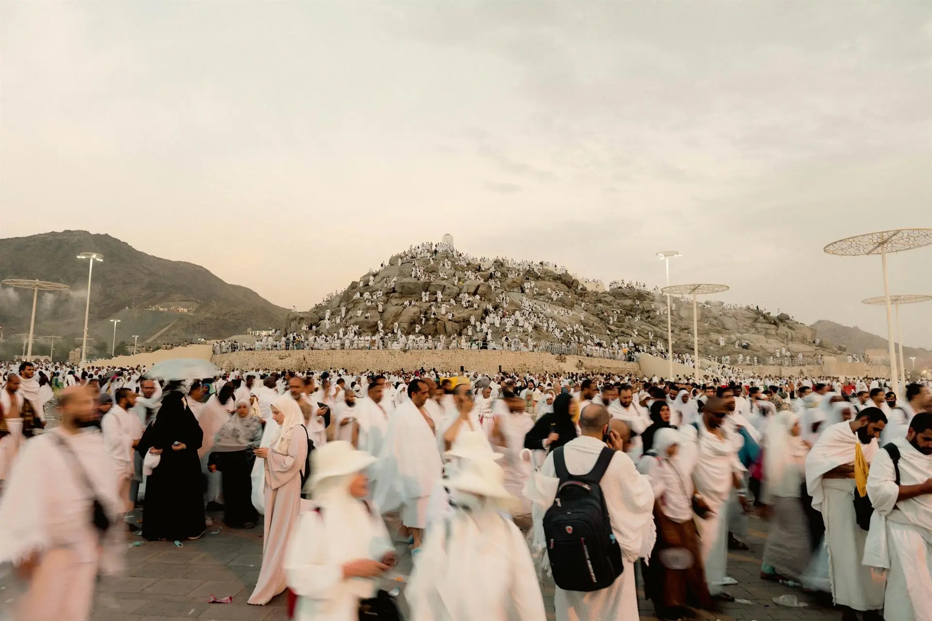 A panoramic perspective of the Arafat site under a clear sky, showcasing its vast terrain.